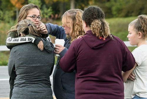 Friends of victims who died comfort eachother at the crash site.