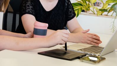 Woman In Wheelchair Collaborating In Modern Office With Coworker in Wheelchair Friendly Office