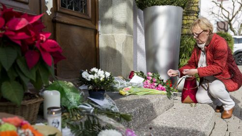 A mourner lays tributes outside the restaurant Hotel de Ville in Crissier, Switzerland.