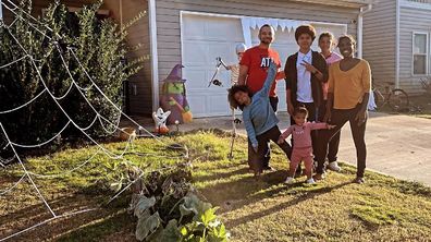 Salena Webb with her family on the front lawn of their home after they removed morbid Halloween decorations to appease a neighbour.