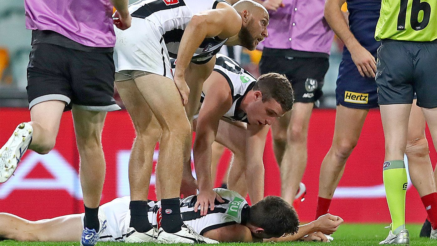 Brody Mihocek of the Magpies lies still on the ground after a collision