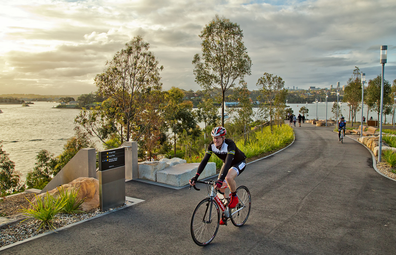 A man and a woman enjoy a bike ride through Barangaroo Reserve in Sydney.