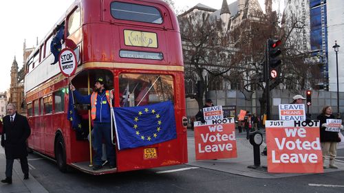 A pro EU campaign bus drives past Vote Leave supporters outside parliament as the Brexit deal continues to divide parliament.