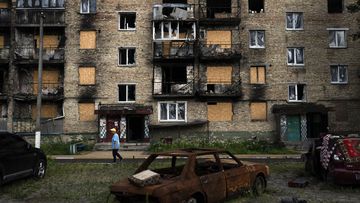 A resident walks past an apartment building heavily damaged in Russian attacks in Irpin, Ukraine.