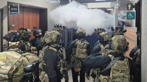 National Assembly employees spray fire extinguishers on soldiers in Seoul, South Korea.