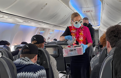 Staff don tropical sunglasses and leis on the second Qantas Mystery Flight to Hamilton Island