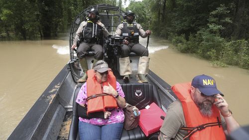 Texas Parks and Wildlife rangers use a boat to rescue residents from flooding in Liberty County, Texas, Saturday, May 4, 2024. (AP Photo/Lekan Oyekanmi)