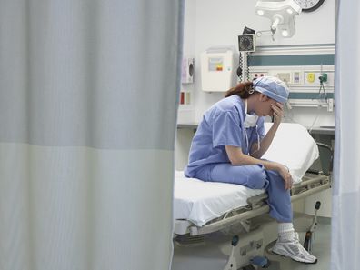 Sad nurse sitting on a hospital bed after long shift