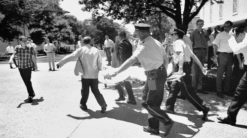  A victim of Charles Joseph Whitman, the sniper who gunned down victims from a perch in the University of Texas tower, is carried across the campus to a waiting ambulance in Austin. (AP)