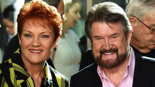 One Nation Senator Pauline Hanson with Senator Derryn Hinch pose for a photo before an induction for new senators at Parliament House in Canberra.