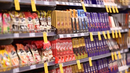 Tempting sweet treats and soft drinks are a regular sight near the checkouts of major Australian supermarkets. (AAP file)