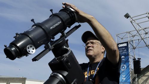 Ray Cooper, volunteer for the Oregon Museum of Science and Industry, preps his equipment to provide live video of the eclipse. (AAP)