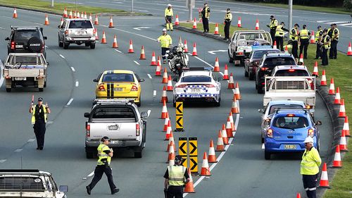 Motorists are stopped at a checkpoint on the Gold Coast Highway at Coolangatta on the Queensland/NSW border border , Thursday, March 26, 2020. 