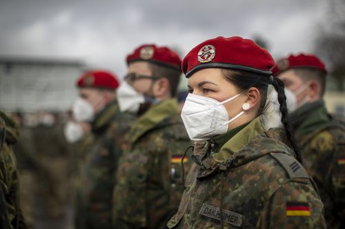 German Bundeswehr soldiers of the NATO enhanced forward presence battalion waits to greet German Defense Minister Christine Lambrecht upon his arrival at the Rukla military base some 100 kms (62.12 miles) west of the capital Vilnius, Lithuania, Tuesday, Feb. 22, 2022. Germany is sending additional troops to Lithuania in response to Russia's military build-up on the border with Ukraine and the worsening security situation in the Baltic states. (AP Photo/Mindaugas Kulbis)