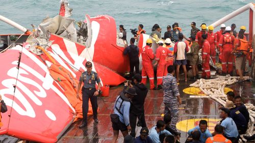 The tail of AirAsia Flight 8501 is seen on the deck of rescue ship Crest Onyx. (AAP)