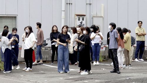 8 Ağustos 2024 Perşembe günü Japonya'nın batısındaki Miyazaki'de meydana gelen depremin ardından insanlar bir binanın dışına sığınıyor.  (AP aracılığıyla Kyodo Haberleri)