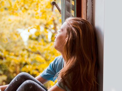 Upset young girl staring out the window