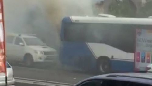 A car nearly rams into the rear of the smoking bus. (Supplied)
