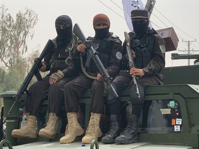 قندهار، افغانستان - 15 اوت: شرکت کنندگان مسلح در جریان تظاهراتی که توسط طالبان و پیروان آنها در حمایت از دومین سالگرد حکومت طالبان در قندهار، افغانستان در 15 اوت 2023 برگزار شد، روی یک خودروی نظامی نشسته اند. (عکس از محمد نوری/ خبرگزاری آنادولی از طریق گتی ایماژ)