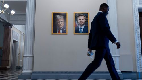 Trump'ın ilk dönem portresi, gülümseyen bir ifadeyle bayrağın önünde yer alıyordu.