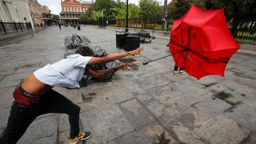 A man in the French Quarter plays with his umbrella in the wind of Tropical Storm Barry in New Orleans, Louisiana.