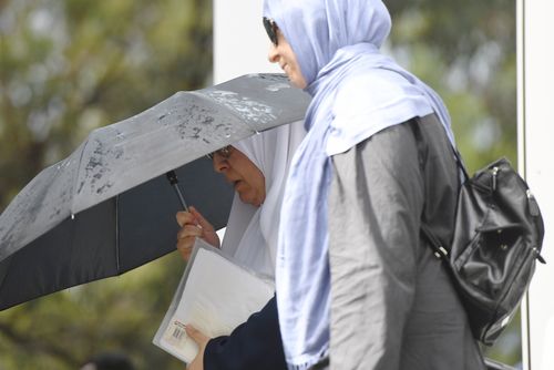 Ms Al-Shennag covered her face with an umbrella as she entered court. (AAP)