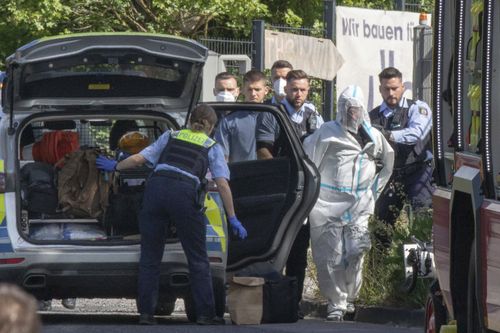 Police officers take the suspected perpetrator away in Herzogenrath, Germany, Friday, May 13, 2022. 