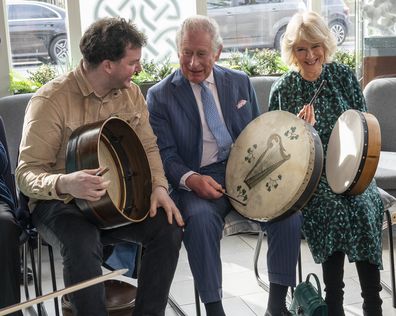 Prince Charles and Camilla learn how to play a frame drum called a bodhran during a visit to the Irish Cultural Centre to celebrate the Centre's 25th anniversary in the run-up to St Patrick's Day 