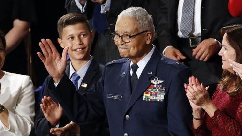 Tuskegee airman Charles McGee, 100, and his great grandson Iain Lanphier react as President Donald Trump delivers his State of the Union address.