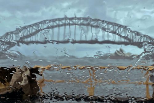 The Sydney Harbor Bridge seen through a car windscreen as rain pours down on the city, Monday, February 28, 2022. The state of New South Wales has seen more than 500 flood rescues and 927 requests for assistance in the last 24 hours as record rain continues to fall in the eastern states of Australia.  (AP Photo/Mark Baker)
