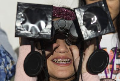 A girl tests special binoculars in the local park.