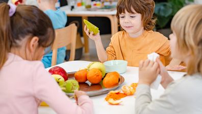 Children eating a fruit snack in a kindergarten