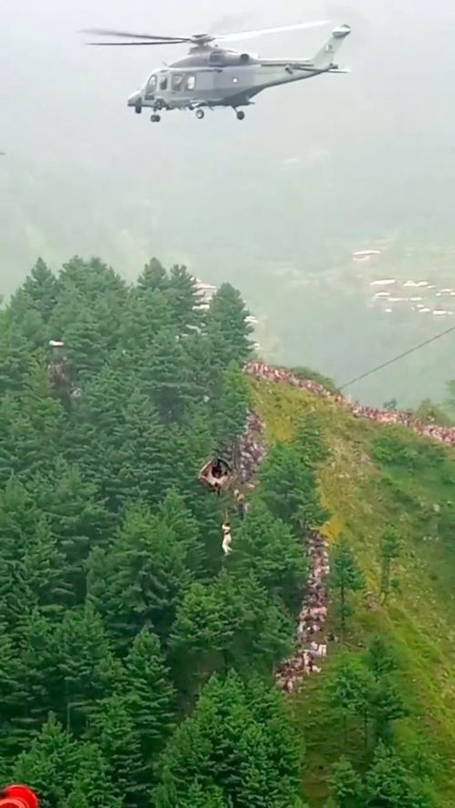 A helicopter rescues a person following a cable car with students stranded mid-air in Battagram, Pakistan, August 22, 2023, in this screen grab obtained from social media video.  
