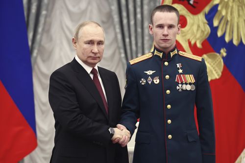 Russian President Vladimir Putin, left, awards Senior Lieutenant Stepan Belov with the Gold Star medal of the Hero of Russia during an awarding ceremony at the Kremlin's St. Catherine Hall in Moscow, Russia, Tuesday, Dec. 20, 2022 