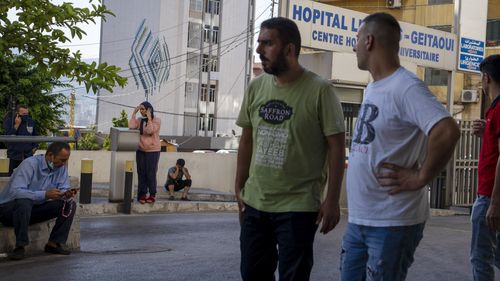 Relatives of people who were severely injured in a fuel explosion in northern Lebanon gather outside a Geitaoui hospital in Beirut, Lebanon.