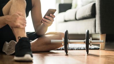 Man on phone workout at home weights