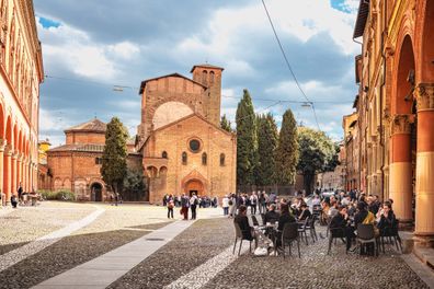 Bologna, Italy - March 10, 2023: People on the paved square with monumental complex of San Giacomo Maggiore in Bologna, Italy