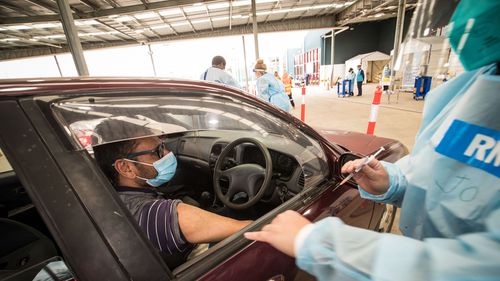   Une infirmière administre le vaccin Pfizer COVID-19 dans un centre de vaccination en voiture à Melton à Melbourne.