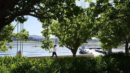 CANBERRA, AUSTRALIA - OCTOBER 08: Exercisers by Lake Burley Griffin on October 08, 2021 in Canberra, Australia. Lockdown restrictions remain in place for Canberra, with residents subject to stay-at-home orders as the ACT continues to record new local COVID-19 cases. The current lockdown restrictions are due to remain in place until Friday 15 October 2021. (Photo by Rohan Thomson/Getty Images)