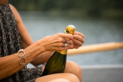 Woman opening a champagne bottle