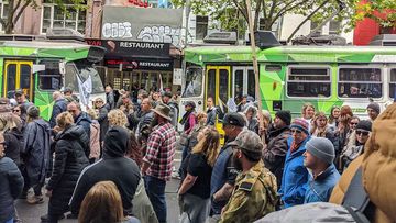 A largely maskless crowd marches through Melbourne&#x27;s CBD.