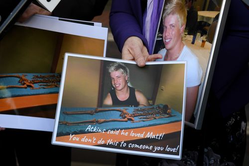 Mark and Faye Leveson hold photographs of their son Matthew's skeletal remains at the coronial inquest. (AAP)