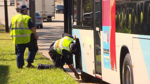 Police inspect the damage to the bus after the crash on Canterbury Road. (9NEWS)