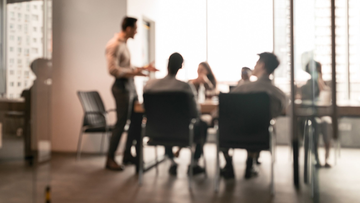 Employees are seen meeting in their workplace.