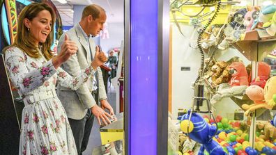 Britain's Prince William and Kate, the Duchess of Cambridge play a game at an amusement arcade, where TV program Gavin and Stacey was filmed, in Barry Island, Wales, Wednesday Aug. 5, 2020, during their visit to speak to local business owners about the impact of COVID-19. 