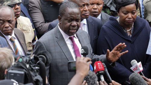 Kenya's Interior Minister Fred Matiangi speaks to reporters outside the complex.