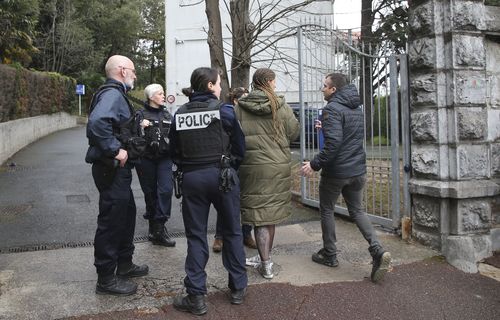 People enter a private Catholic school after a teacher has been stabbed to death by a high school student, Wednesday, Feb. 22, 2023 in Saint-Jean-de-Luz, southwestern France 