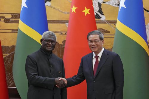 Solomon Islands Prime Minister Manasseh Sogavare, left, shakes hands with his Chinese counterpart Li Qiang after they witnessed signing on agreement for both countries at the Great Hall of the People in Beijing, July 10, 2023. 