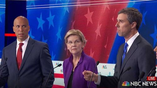 Cory Booker and Elizabeth Warren look on as Beto O'Rourke starts speaking in Spanish.