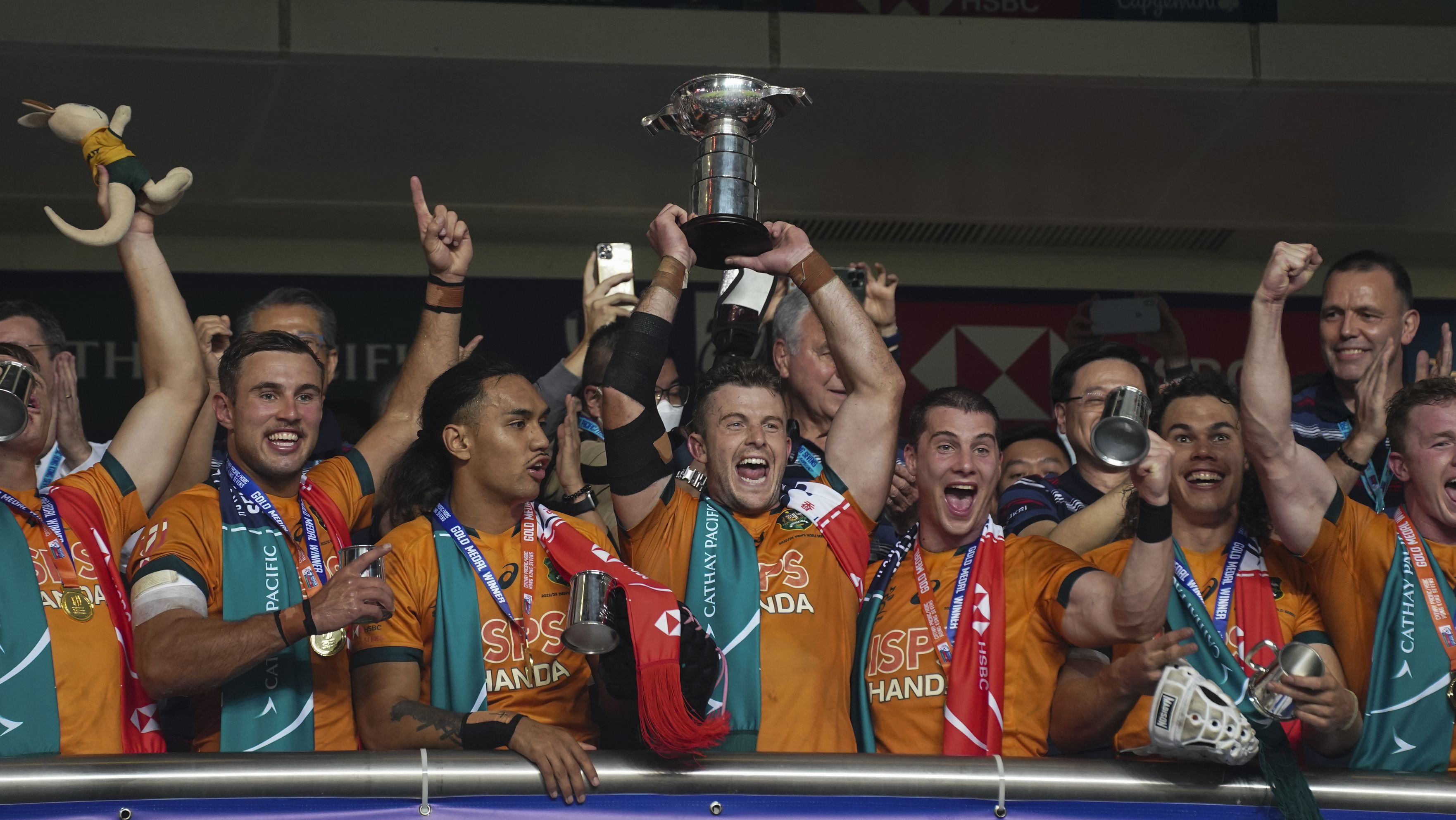 Australia players celebrate with their trophy after winning in the Hong Kong Sevens rugby tournament in Hong Kong, Sunday Nov. 6, 2022. (AP Photo/Anthony Kwan)